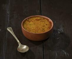 indisch berühmt Küche dal tadka auf Jahrgang hölzern Hintergrund foto