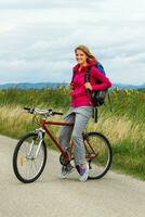 Frau Wanderer Sitzung auf ein Fahrrad im das Natur foto