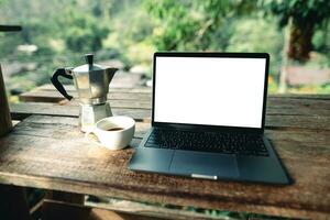 Laptop auf Tabelle mit Kaffee und Lager Grafiken foto