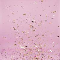 fallendes goldenes Konfetti über rosa Hintergrund foto