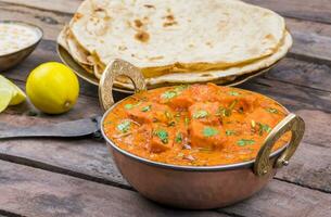 indisch köstlich Küche Paneer Tikka Masala mit Tandoori Chapati auf hölzern Hintergrund foto