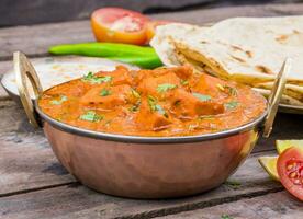 indisch köstlich Küche Paneer Tikka Masala mit Tandoori Chapati auf hölzern Hintergrund foto