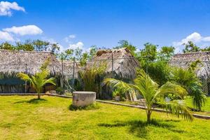 Eingangspfad des tropischen Strandes zwischen natürlichen Hütten in Mexiko.