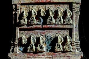 ein geschnitzt Panel mit mehrere buddhas auf es foto