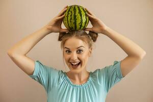 süß spielerisch Frau halten Wassermelone auf ihr Kopf.getönt Bild. foto