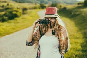 schön jung Frau beim das Land Straße genießt fotografieren.getönt Bild. foto