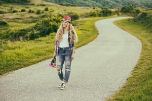 schön jung Frau halten Strauß von Blumen und Gehen beim das Land Straße. foto