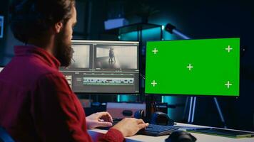 Video Editor Analysieren Film Montage auf isoliert Bildschirm Anzeige Vor Bearbeitung Farbe Benotung und Beleuchtung im kreativ Büro. Post Produktion Studio Mitarbeiter Arbeiten mit roh Aufnahmen auf Chroma Schlüssel pc foto