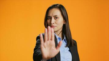 Filipino Frau zeigen halt Zeichen mit Palme, Werbung Negativität und Nein Symbol auf Kamera. weiblich Modell- tragen formal Kleidung im Studio, präsentieren Ablehnung und ablehnen etwas. foto