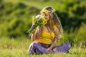 Frau mit Kranz im ihr Haar halten Blumen im Natur. foto