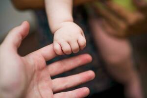 schließen oben Bild von Vaters und seine Baby Junge Sohn Hände halten jeder andere. Fokus auf Finger. foto