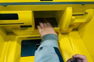 Kinder Hand mit Druckknopf Steuerung Panel auf Geldautomat zum Kasse Rückzug foto