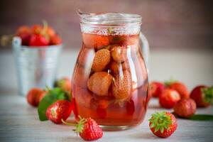 Süss erfrischend Beere Kompott von reif Erdbeeren im ein Karaffe foto