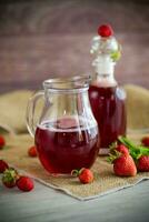 Süss gekocht Erdbeere Sirup im ein Glas Karaffe foto