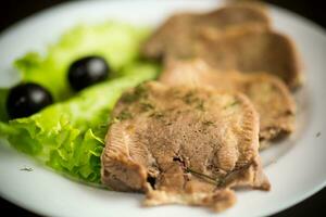 gekocht Rindfleisch Zunge geschnitten im ein Teller foto