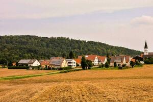 ein Dorf im das Landschaft mit ein Kirche im das Entfernung foto