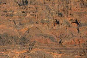 ein groß Felsen Formation im das Wüste mit ein Person Stehen auf oben foto