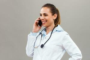 schön weiblich Arzt mit Handy, Mobiltelefon Telefon. foto