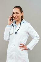 schön weiblich Arzt mit Handy, Mobiltelefon Telefon. foto