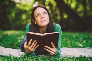 Frau lesen Buch und Denken im Park foto