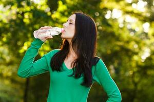 Frau Trinken Wasser draussen foto