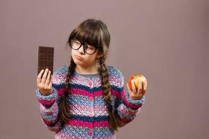 wenig Nerd Mädchen will Essen Schokolade lieber dann Obst foto