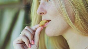blond Mädchen Essen Chips auf das Straße. foto