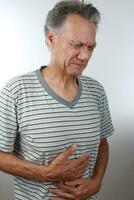 älter reifen Mann halten seine Magenschmerzen weil von Schmerzen foto