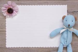 Holzbrett Tisch weißes Briefpapier blauer Bär Puppe lila Blume foto