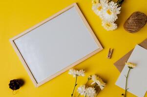 Whiteboard mit Umschlag und Blume ist auf gelbem Hintergrund platziert foto