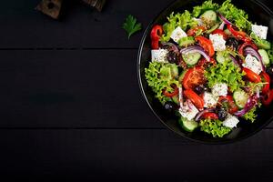 gesund Lebensmittel. griechisch Salat mit Gurke, Tomate, Süss Pfeffer, Kopfsalat, rot Zwiebel, Feta Käse und Oliven. oben Sicht, Kopieren Raum foto