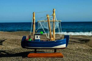 ein Modell- von ein Angeln Boot auf das Strand foto