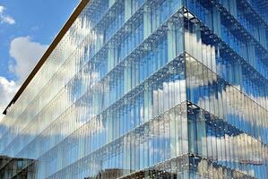 Glas Gebäude mit transparent Fassade von das Gebäude und Blau Himmel. strukturell Glas Mauer reflektieren Blau Himmel. abstrakt modern die Architektur Fragment. zeitgenössisch architektonisch Hintergrund. foto