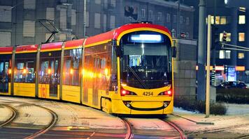 Warschau, Polen. 5 Dezember 2023. modern Straßenbahn warten zum Grün Licht foto