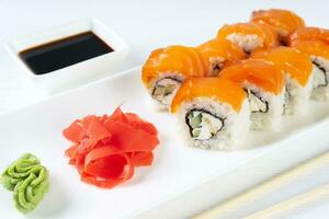 Sushi rollen Philadelphia mit Lachs, geräuchert Aal, Avocado, Sahne Käse auf Weiß Hintergrund foto