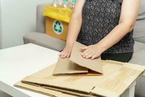 Zuhause recyceln Öko Null Abfall Konzept Frau mit recyceln Papier Kasten. Stapeln braun Karton Box Öko freundlich Verpackung gemacht von recycelbar roh Materialien. foto