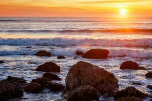 atlantisch Ozean Sonnenuntergang mit Wellen und Felsen beim Costa da Caparica, Portugal foto