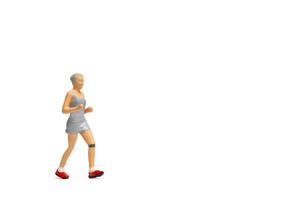 Miniaturmenschen, Frau in Fitnesskleidung, die auf weißem Hintergrund läuft foto