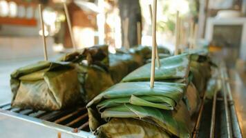 lokal Essen im Nord Thailand gemacht mit gehackt Schweinefleisch und Kokosnuss Milch eingewickelt im Banane Blätter gegrillt auf das Herd. foto