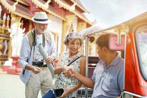 europäisch Senior Tourist Frau sind Glückwunsch Handschlag mit das Tuk Tuk Thailand Taxi Treiber auf thailändisch Tempel Hintergrund. Senior Tourist Konzept foto