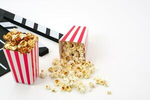 Klappe oder Film Schiefer schwarz Farbe mit Popcorn auf Weiß Hintergrund. Kino Industrie, Video Produktion und Film Konzept. foto