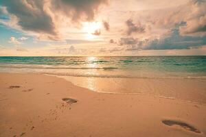 Nahansicht von Fußabdrücke im das Sand auf das Strand beim Sonnenuntergang. still exotisch Reise und Sommer- Landschaft Konzept. Strand Sonnenuntergang, still Sonnenuntergang Himmel und Wolken. friedlich inspirierend Natur foto