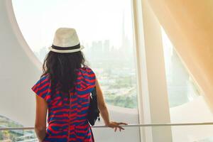 Dubai, Vereinigte Arabische Emirate, 2022 - - kaukasisch Tourist im berühmt Rahmen Wahrzeichen genießen Panorama von Stadt Horizont. Besuch VAE Urlaub Reise Ziele Besichtigung im Dubai Konzept foto