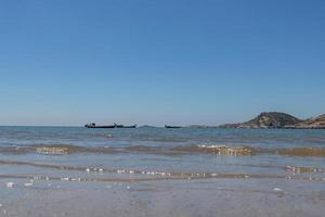 das Meer unter blauem Himmel, saubere Strände und Meerwasser sowie Inseln und Windmühlen foto