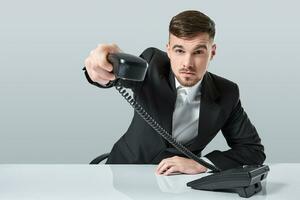 Porträt von attraktiv Geschäftsmann halten Telefon im seine Hand. diese Anruf ist zum Sie Konzept foto