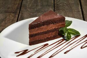 Scheibe von Schokolade Schwamm Kuchen mit Buttercreme und Schokolade Ganache foto