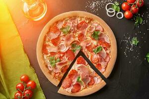 oben Aussicht von geschnitten Pizza mit Salami, Speck und Prosciutto foto