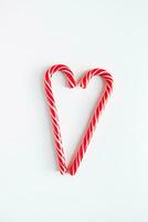 zwei Weihnachten Süßigkeiten Stöcke im das gestalten von ein Herz. Valentinstag Tag Konzept. Platz zum Text. foto