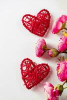 Blumen und rote Herzen auf weißem Hintergrund zum Valentinstag foto