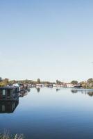 Aussicht von das Kanal und das Stadtrand von Amsterdam. friedlich Leben Nächster zu beschäftigt Leben. Landschaft Lebensstil foto